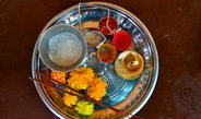 <p>A <em>pūjeca tāṭ</em>. The contents of this plate – incense sticks, marigold flowers, an oil lamp, sugar, gulal, kumkum, turmeric powder, and rice – are used during ritualistic ceremonies to worship a deity.<br /><br />Photo: Kalindi Kokal, Paaj Pandhari, Maharashtra, India, 2015<br />Max Planck Institute for Social Anthropology</p>