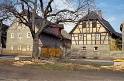 The village of Breunsdorf was torn down in 1995 in the wake of an expanding surface mine. These two photographs show one of the farm houses before and during its devastation.