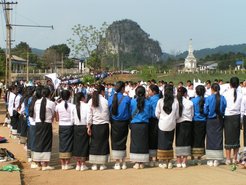 Students awaiting an official delegation; in the background a ‘stupa for the unknown soldier’ (Viengsay)