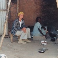 Andrea Behrends sitting in an outside kitchen in Adré.
